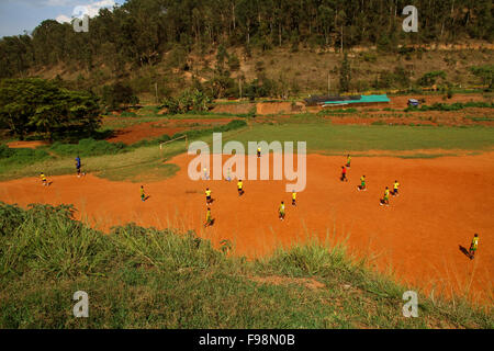 A group of African children, in Rwanda, Kigali, play soccer on a dirt field Stock Photo
