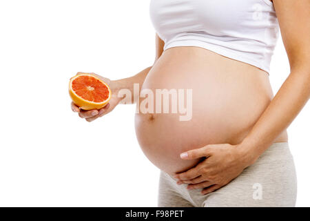 Unrecognizable pregnant woman holding grapefruit, isolated on white background Stock Photo