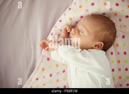 Cute newborn baby girl sleeping in bed at home Stock Photo