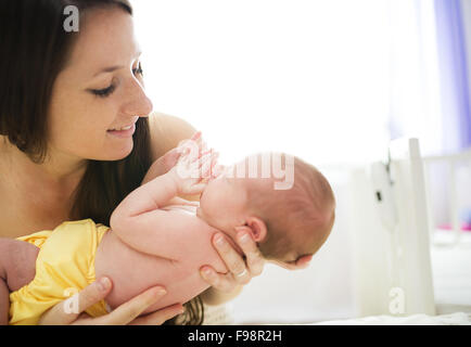 Happy mother with baby girl inside of room. Stock Photo