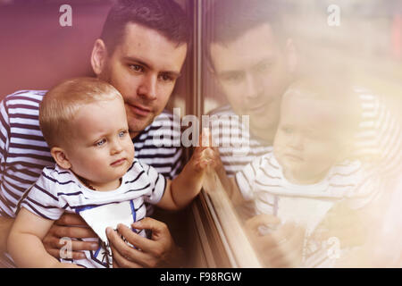 Father with son travel in retro train. They are looking out of window. Stock Photo