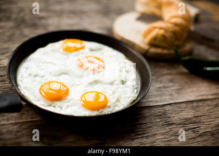 Fried egg in a frying pan on a wooden table Stock Photo