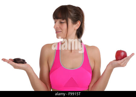 Fitness sports young fit slim woman comparing apple fruit with chocolate diet isolated on a white background Stock Photo