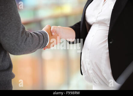 Unrecognizable businessman and businesswomen having a meeting in shopping mall. Woman is pregnant. Stock Photo