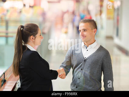 Businessman and businesswomen having a meeting in shopping mall. Woman is pregnant. Stock Photo