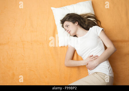 Sick woman is lying on the bed. Stock Photo