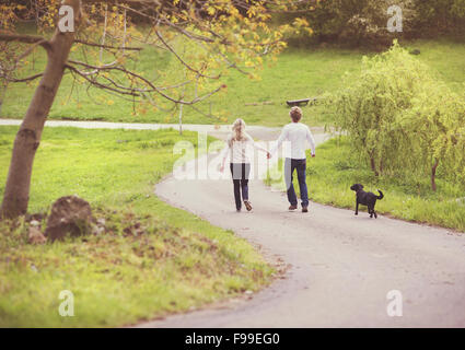 Young beautiful couple taking a walk in green park Stock Photo