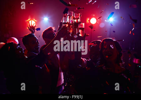 Young friendly people toasting in night club Stock Photo