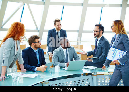 Young employees discussing and explaining new ideas at meeting Stock Photo