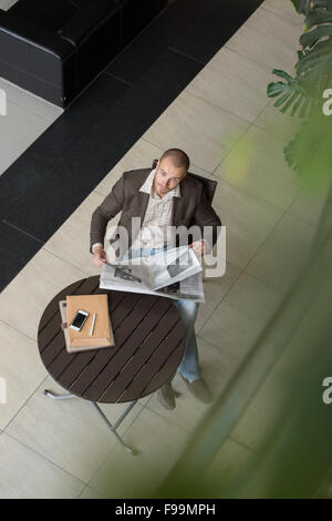 Handsome businessman or manager in office building reading newspaper view from above Stock Photo