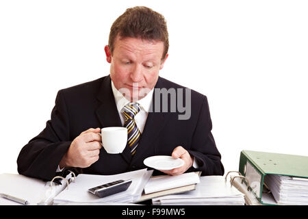 Elderly manager drinking a cup of coffee and reading files Stock Photo