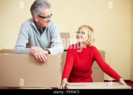 Two happy senior people with many moving boxes Stock Photo