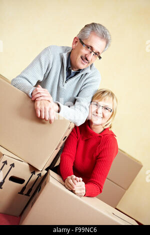 Two happy senior people with many moving boxes Stock Photo