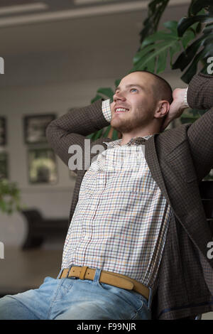 Satisfied businessman relaxing in his office or restaurant Stock Photo