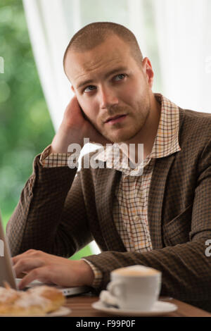 Business man working on his laptop at sidewalk cafe Stock Photo