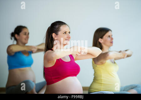 Group of young pregnant women doing relaxation exercise on exercising mat Stock Photo
