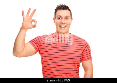 Joyful young man making an OK hand sign and looking at the camera isolated on white background Stock Photo