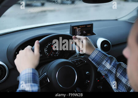 young man using new car navigation and onboard vehicle transport system Stock Photo