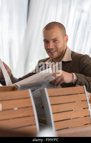 Pensive businessman reading a newspaper in cafe Stock Photo