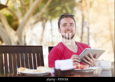 Young handsome man relaxing and using digital tablet Stock Photo