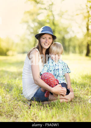 Happy young mother having fun with her little son in nature Stock Photo