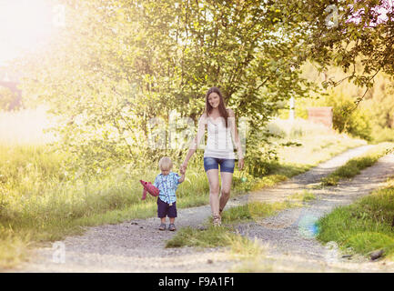 Happy young mother walking with her little son in nature Stock Photo