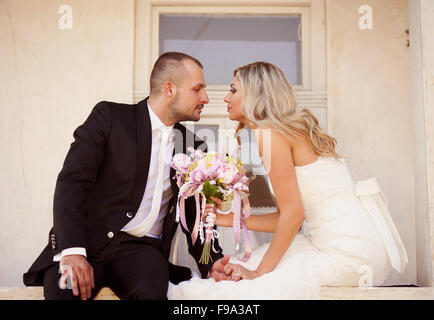 Happy bride and groom posing by the old house Stock Photo - Alamy