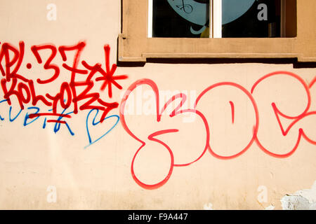 Red graffiti on a wall with a window Stock Photo