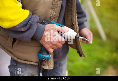 Detail of handyman holding electrical drilling machine Stock Photo