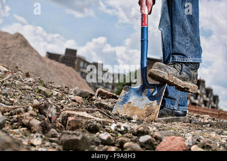 Worker using a spade on a construction site Stock Photo