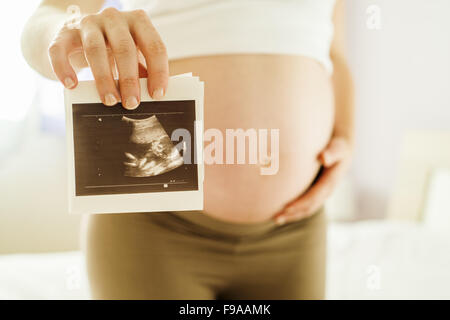 Unrecognizable pregnant woman holding ultrasound scan picture Stock Photo