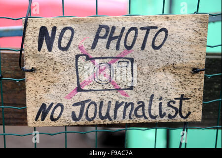 Hand made No Photographs, No Journalists sign on the entrance to the Women and Children Centre in the  Calais 'Jungle' on a rainy morning. Stock Photo