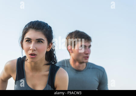 Cheerful Hispanic Caucasian couple running on beach at morning Stock Photo