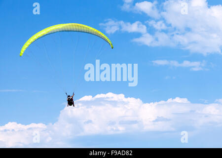 Burgas, Bulgaria - July 23, 2014: Paragliders in blue sky with clouds, tandem of instructor and beginner Stock Photo