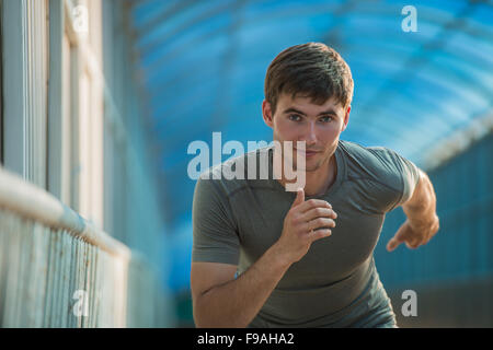 Runner athlete running on road in city. Man fitness sunrise jogging workout wellness concept. Stock Photo