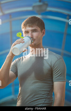 Athletic young man drinking water after hard training Stock Photo