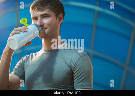 Athletic young man drinking water after hard training Stock Photo