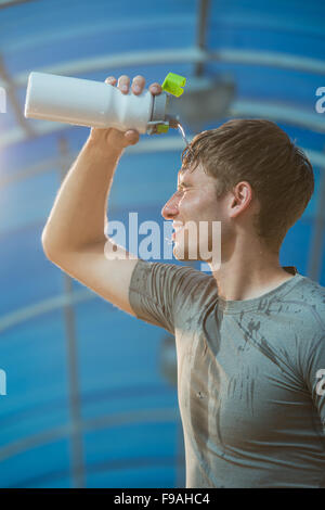 Athletic young man drinking water after hard training Stock Photo