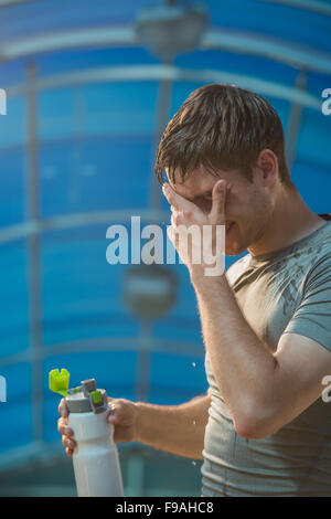 Athletic young man drinking water after hard training Stock Photo