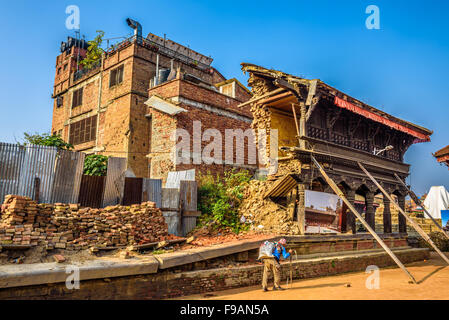 Old man walks around a building destroyed by earthquake Stock Photo