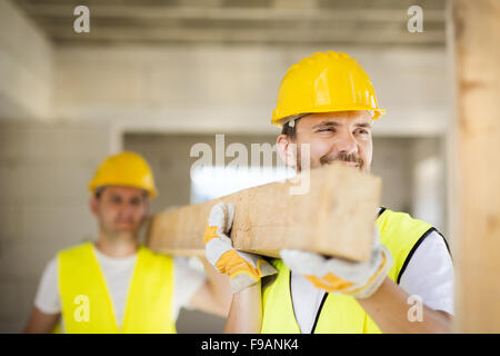 Construction workers collaborating on new house building Stock Photo