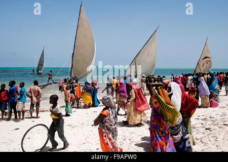 Villagers in colorful clothes from the village of Jambiani in Zanzibar gather to watch the annual Dhow race Stock Photo