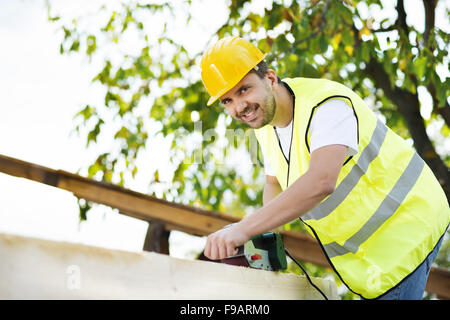Construction worker is working with wooden beam Stock Photo - Alamy