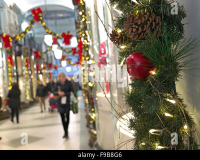 CHRISTMAS SHOPPING SHOPPERS The Piccadilly Arcade with Christmas decorations and shoppers in b/g Piccadilly  London UK Stock Photo