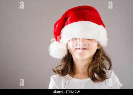 Happy small girl in large santa hat Stock Photo