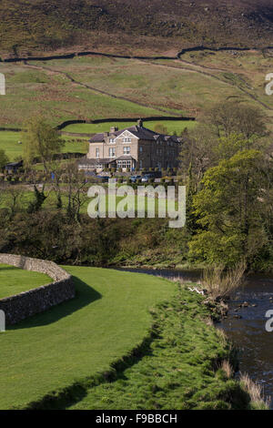 Scenic, rural view of bend in the River Wharfe &The Devonshire Fell Hotel set on rolling, green hillside (fells). Burnsall, Yorkshire Dales, GB, UK. Stock Photo