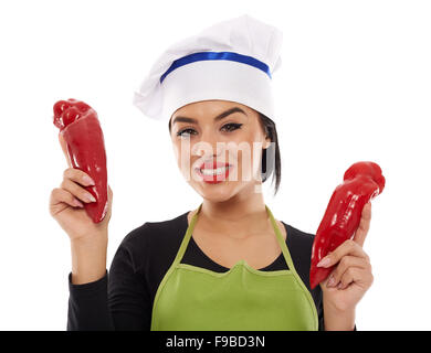 Woman cook holding two large red peppers on white background Stock Photo