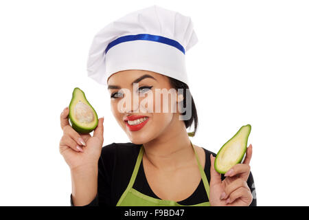 Woman cook holding an avocado sliced on white background Stock Photo