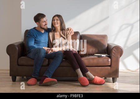 Portrait of sweet couple sitting on couch Stock Photo