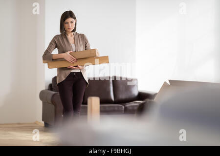 Young woman doing DIY repairs at home putting together self assembly furniture Stock Photo